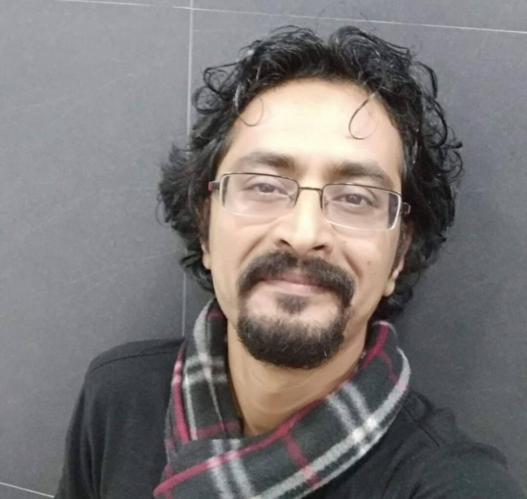 Portrait of a man with glasses and a scarf, representing the Charwaha brand story.