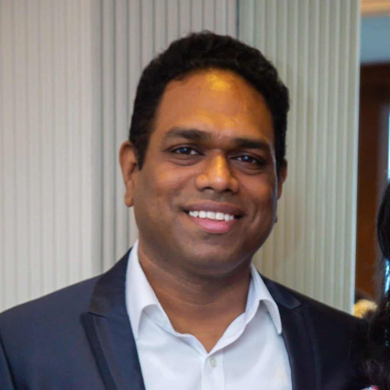 Person smiling at Charwaha event, representing community and growth.